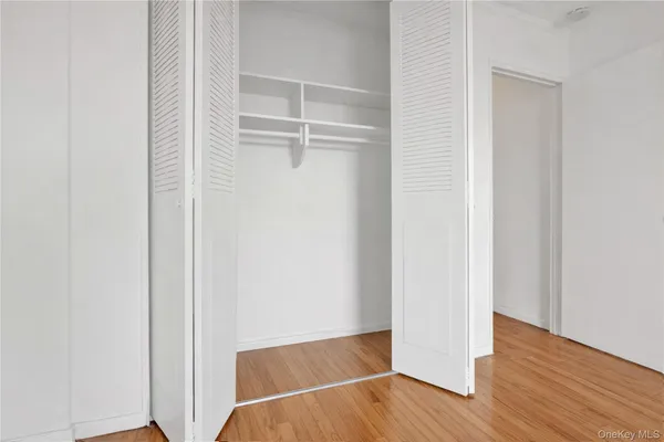 a view of walk in closet with wooden floor