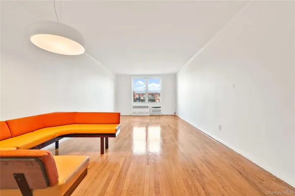 an empty room with a window and wooden floor