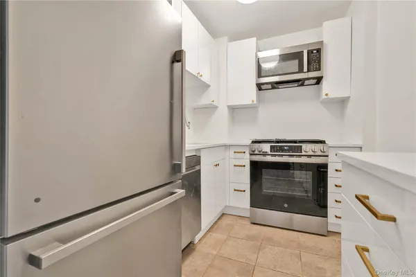 a kitchen with white cabinets and stainless steel appliances
