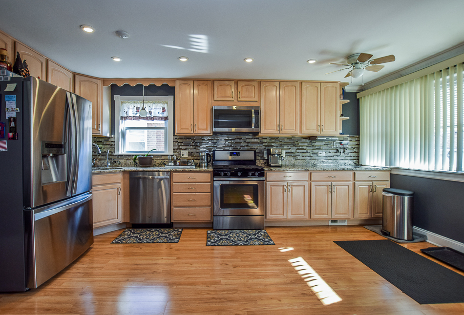 5104 South Rutherford Avenue Chicago, IL 60638 - Photo 10 of 23 a kitchen with granite countertop a refrigerator and a stove top oven