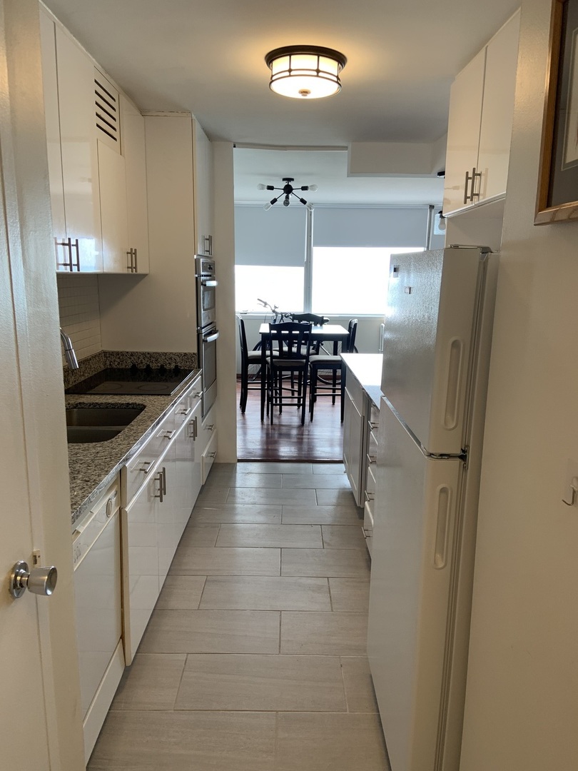 6301 North Sheridan Road, Unit 6L Chicago, IL 60660 - Photo 4 of 21 a kitchen with a refrigerator a table and chairs