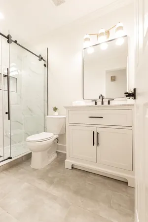 a bathroom with a toilet sink a mirror and shower