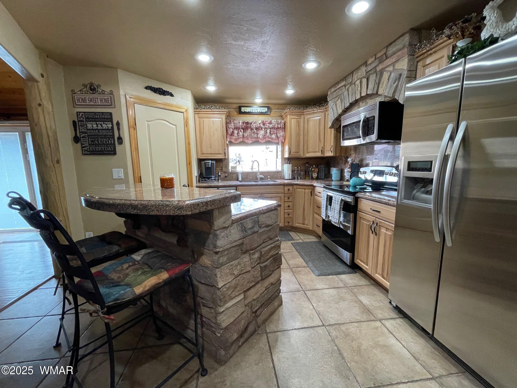 183 North Becker Lake Road Springerville, AZ 85938 - Photo 16 of 41 a kitchen with stainless steel appliances kitchen island granite countertop a sink refrigerator and cabinets