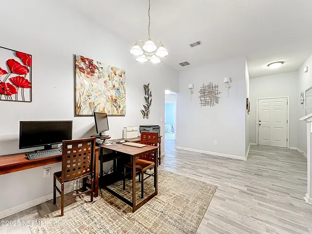 a view of a workspace with furniture and wooden floor