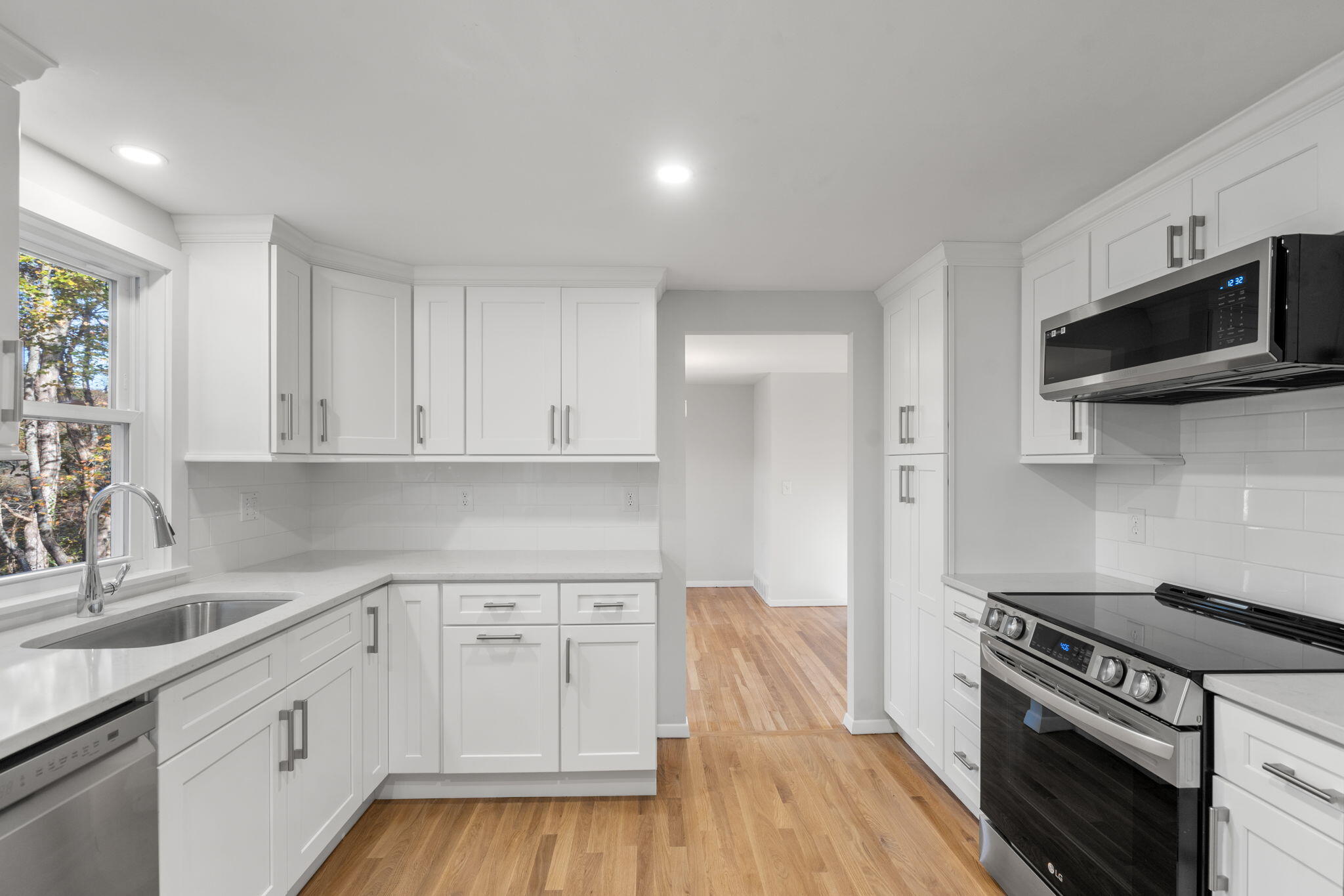 118 Fox Hill Road Centerville, MA 02632 - Photo 14 of 22 a kitchen with white cabinets stainless steel appliances and wooden floor