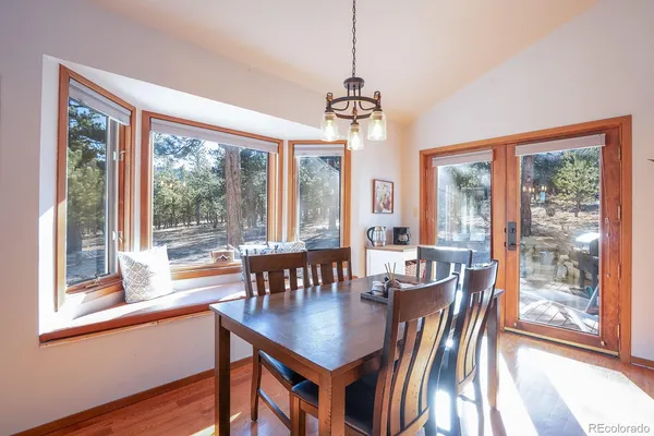 a view of a dining room with furniture large windows and wooden floor