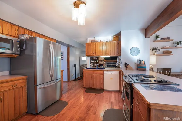 a kitchen with granite countertop a refrigerator stove and sink