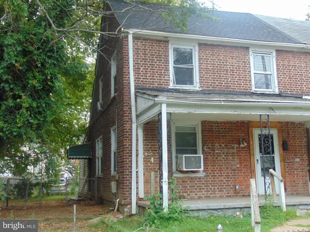 a view of a house with a yard and a large tree