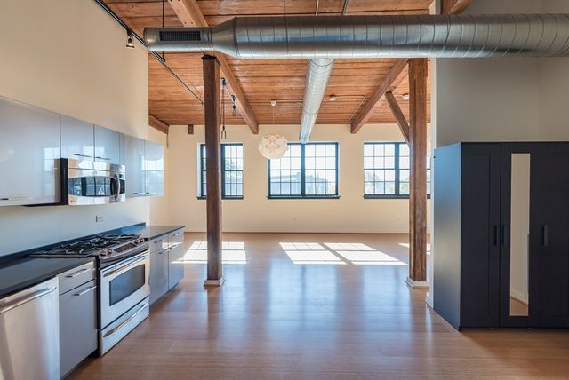 a kitchen with stainless steel appliances granite countertop a stove top oven a sink and a refrigerator