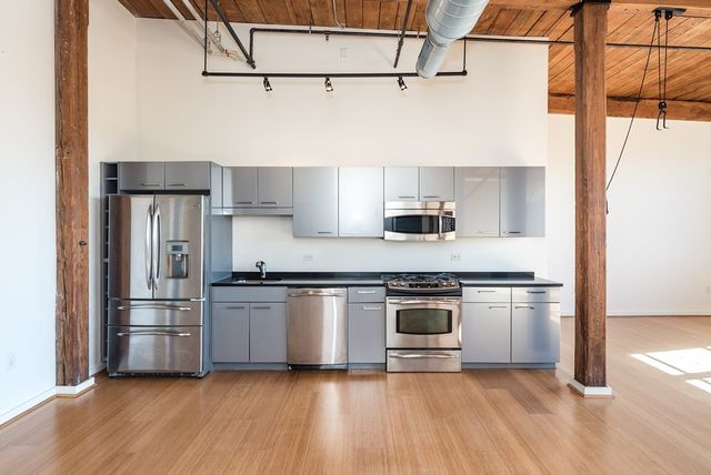 a kitchen with stainless steel appliances granite countertop a refrigerator and a stove