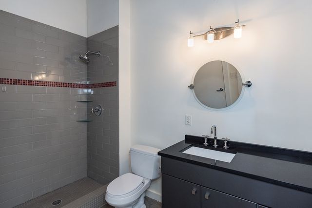 a bathroom with a granite countertop sink mirror and toilet