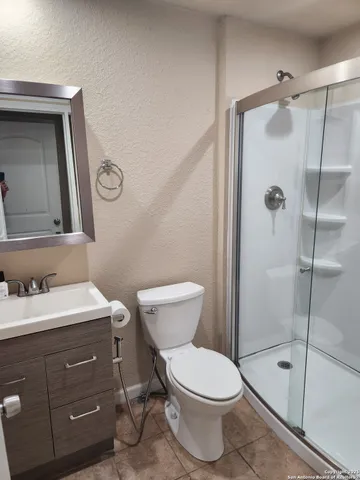 a bathroom with a toilet sink vanity and shower