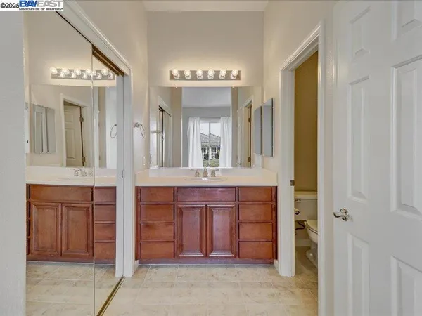 a spacious bathroom with a double vanity sink a large mirror and a bathtub