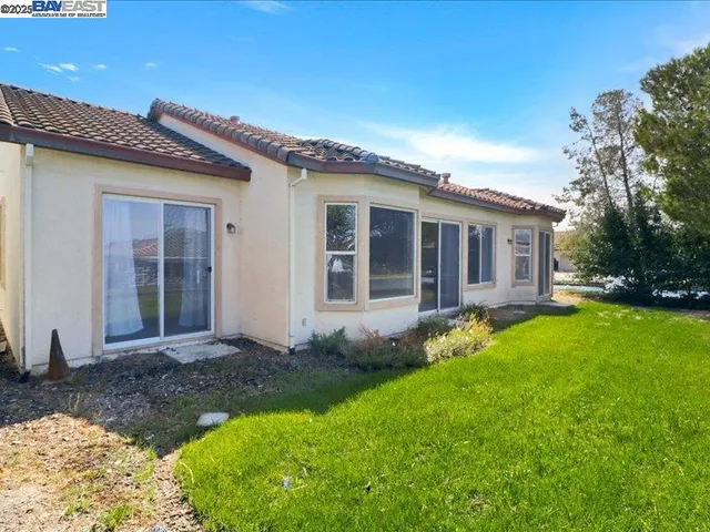 a view of a house with yard and sitting area