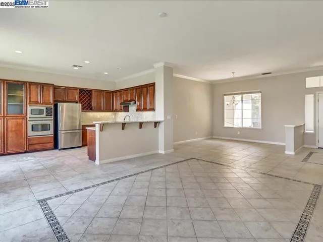 a kitchen with stainless steel appliances granite countertop a refrigerator and a stove top oven