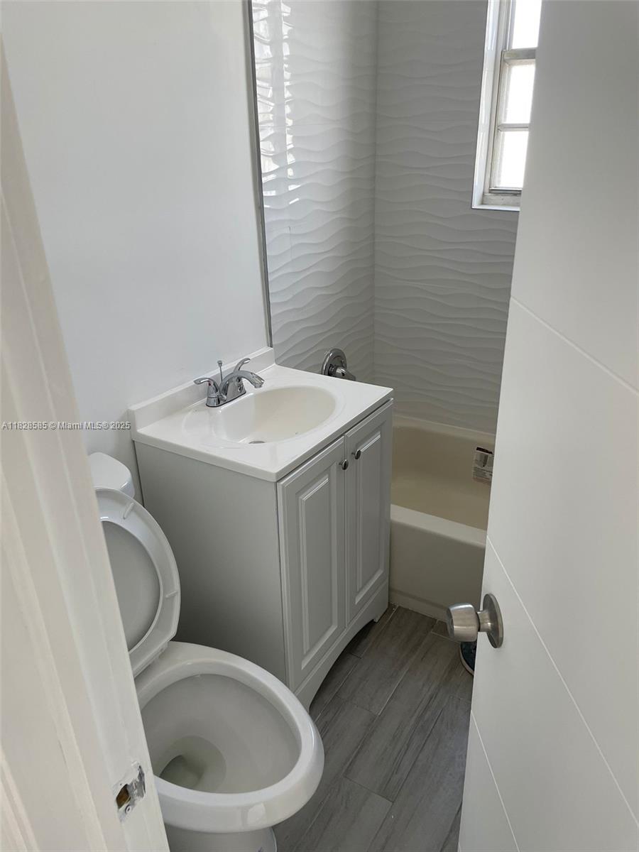 1261 Northwest 59th Street, Unit 5 Miami, FL 33142 - Photo 6 of 6 a bathroom with a toilet sink and mirror