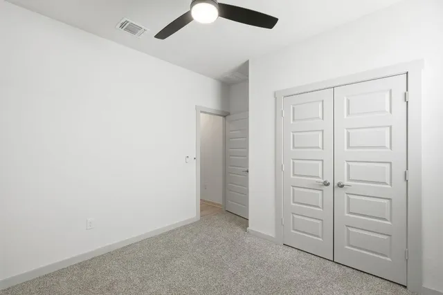 an empty room with a window and a fan