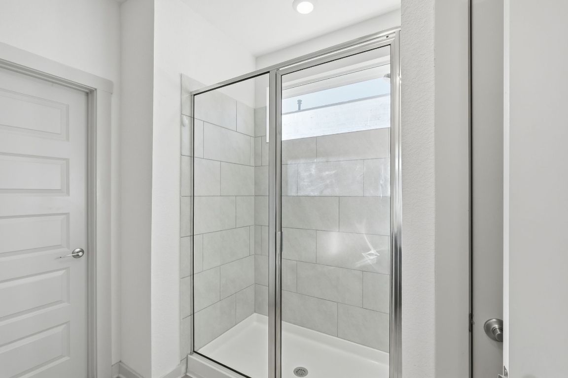 10912 Fulton Avenue Austin, TX 78754 - Photo 6 of 15 a bathroom with a glass shower door