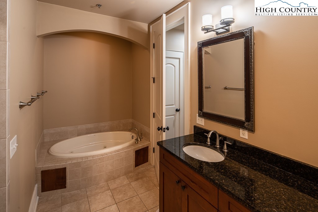 148 Highway 105 Extension, Unit 203 Boone, NC 28607 - Photo 12 of 25 a bathroom with a granite countertop sink and a mirror
