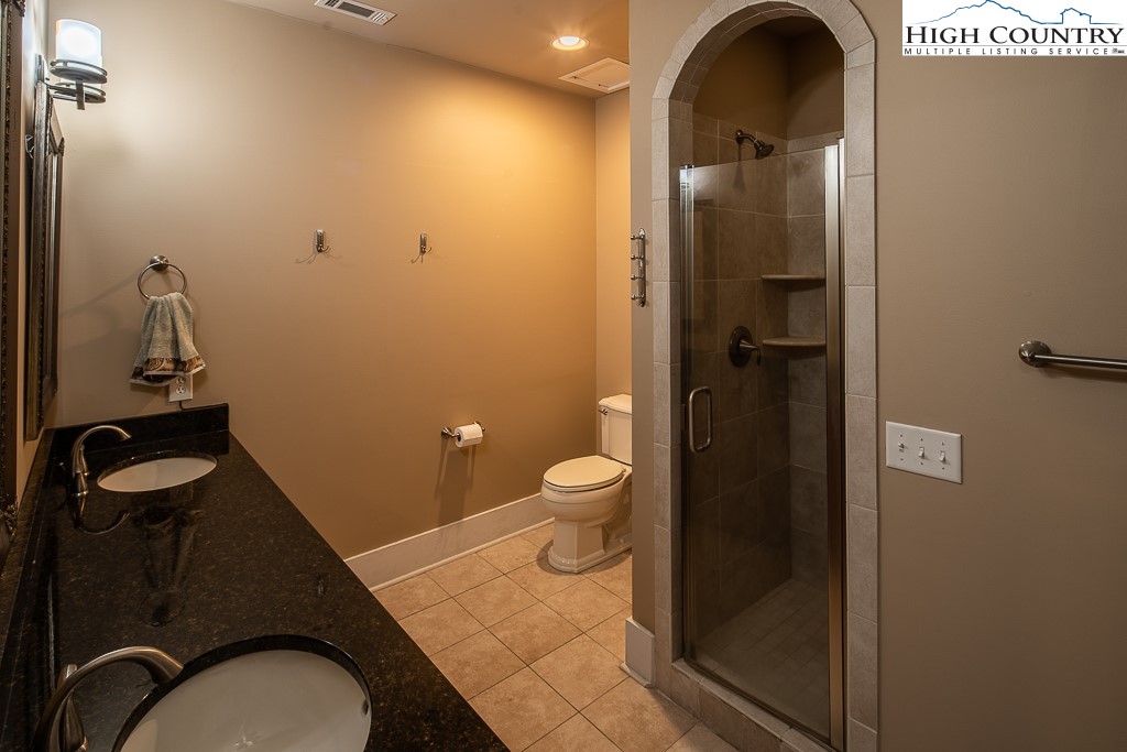 148 Highway 105 Extension, Unit 203 Boone, NC 28607 - Photo 10 of 25 a bathroom with a granite countertop toilet and a sink