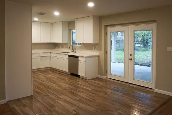 an empty room with wooden floor and chandelier