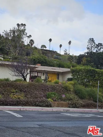 a front view of a house with a yard and potted plants