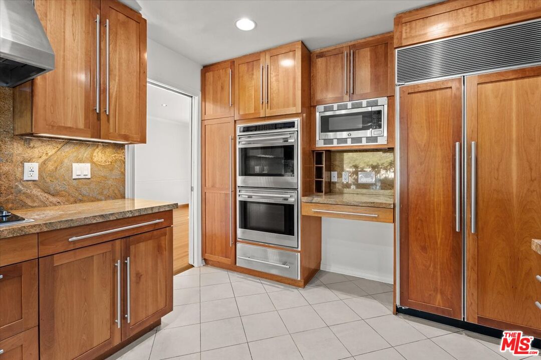13521 Bayliss Road Los Angeles, CA 90049 - Photo 15 of 46 a kitchen with stainless steel appliances a refrigerator and cabinets