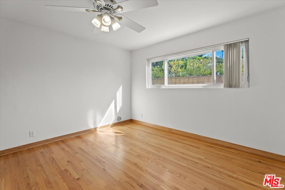 13521 Bayliss Road Los Angeles, CA 90049 - Photo 17 of 46 a view of empty room with wooden floor and fan