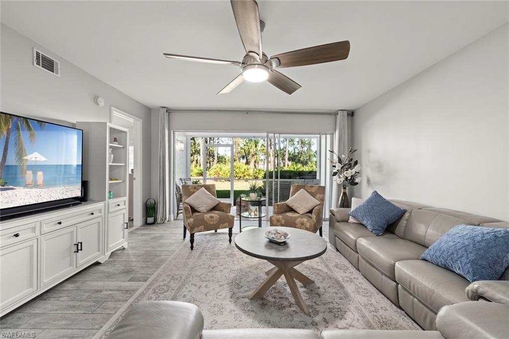 5965 Bloomfield Circle, Unit B104 Naples, FL 34112 - Photo 11 of 39 a living room with furniture and a large window