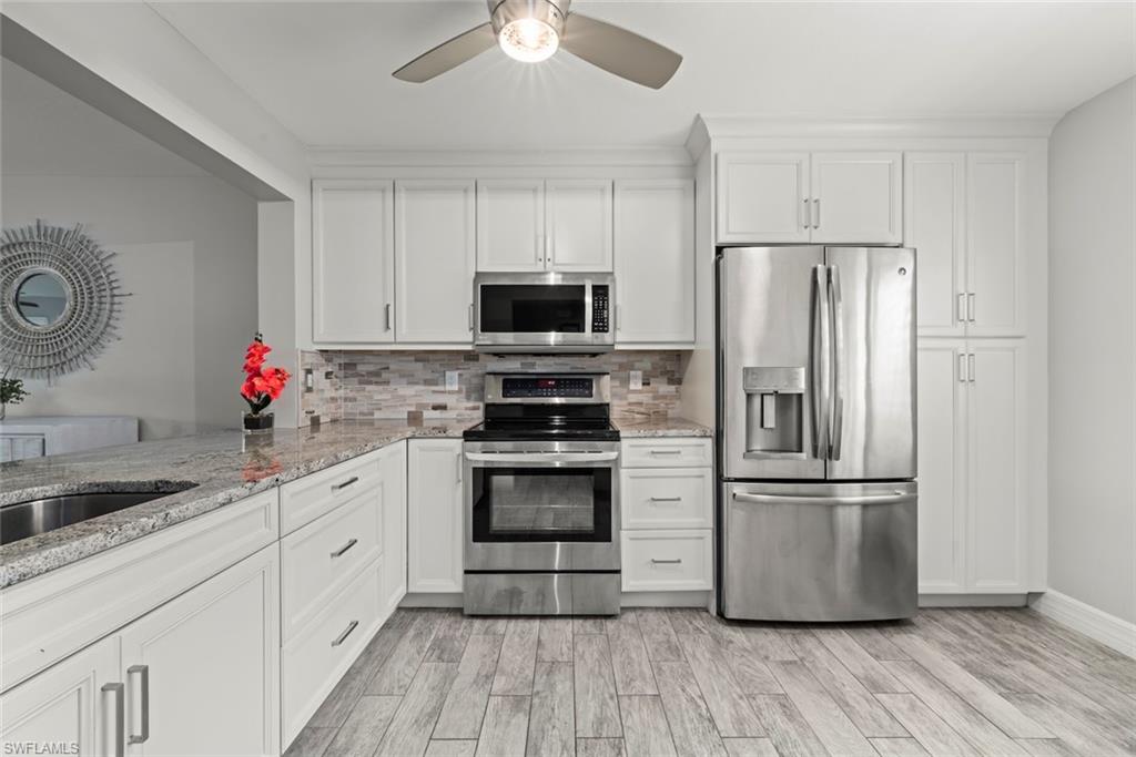 5965 Bloomfield Circle, Unit B104 Naples, FL 34112 - Photo 2 of 39 a kitchen with stainless steel appliances a refrigerator sink and microwave