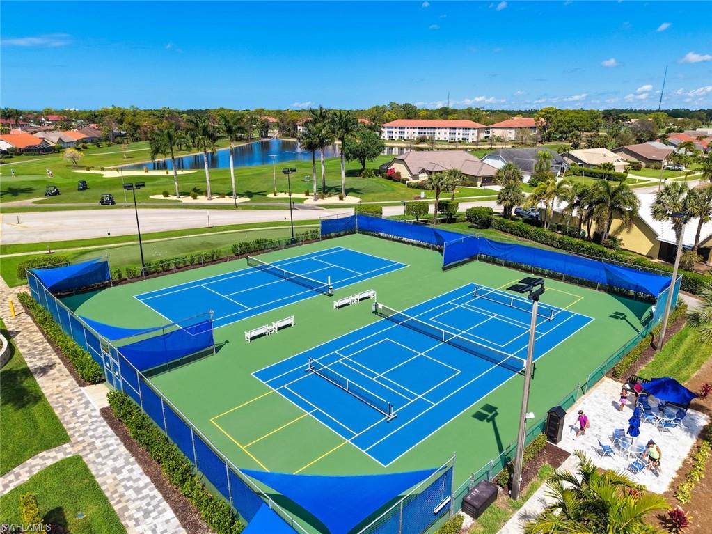 5965 Bloomfield Circle, Unit B104 Naples, FL 34112 - Photo 29 of 39 a view of a tennis ground with large trees