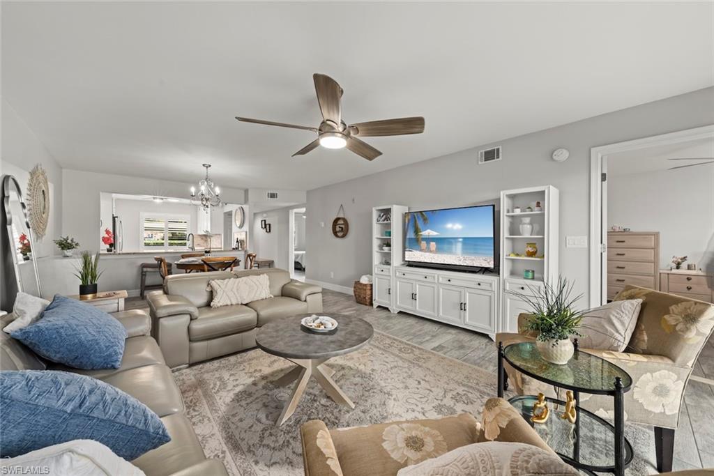 5965 Bloomfield Circle, Unit B104 Naples, FL 34112 - Photo 4 of 39 a living room with furniture and a flat screen tv