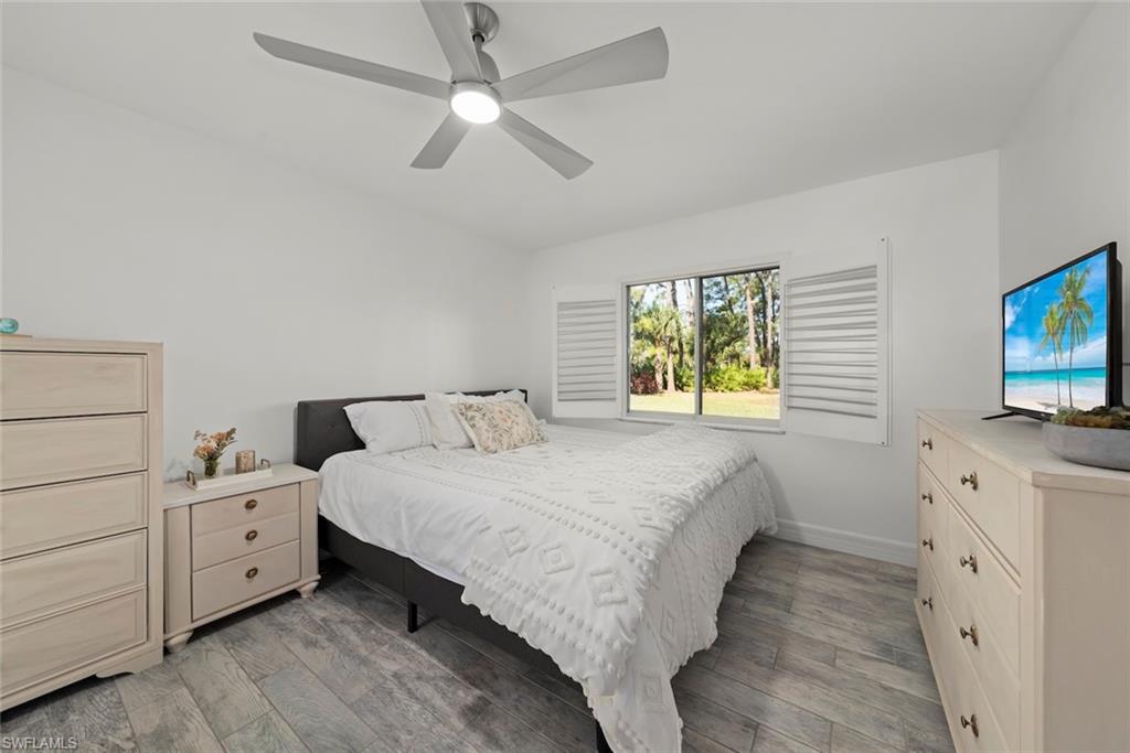 5965 Bloomfield Circle, Unit B104 Naples, FL 34112 - Photo 5 of 39 a bedroom with a bed and a flat screen tv