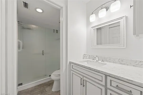 a bathroom with a sink a toilet and shower