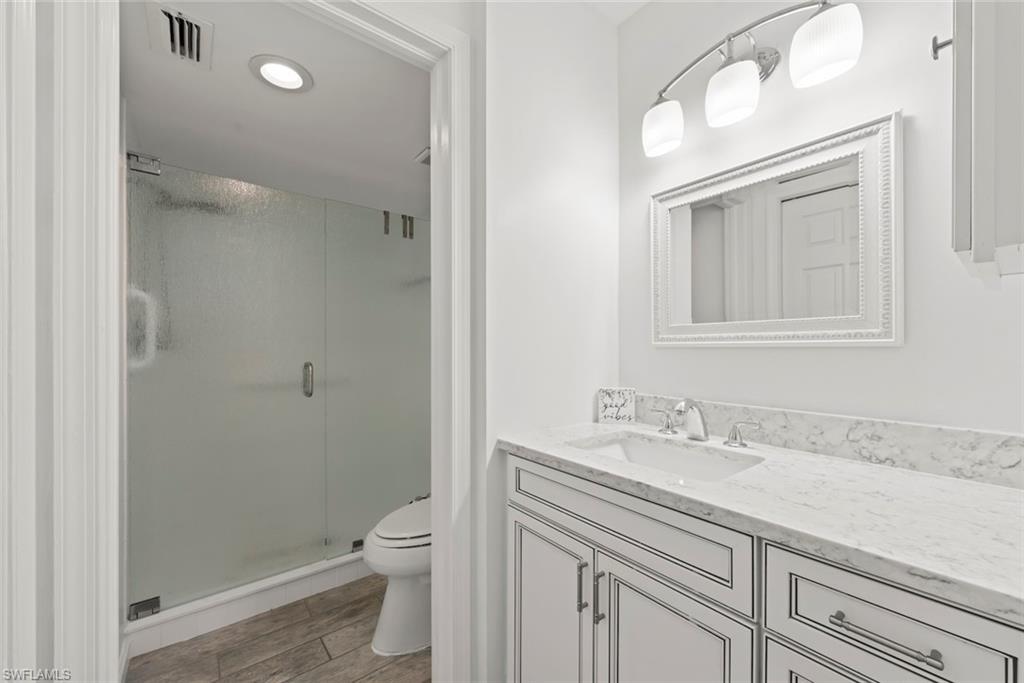 5965 Bloomfield Circle, Unit B104 Naples, FL 34112 - Photo 6 of 39 a bathroom with a sink a toilet and shower