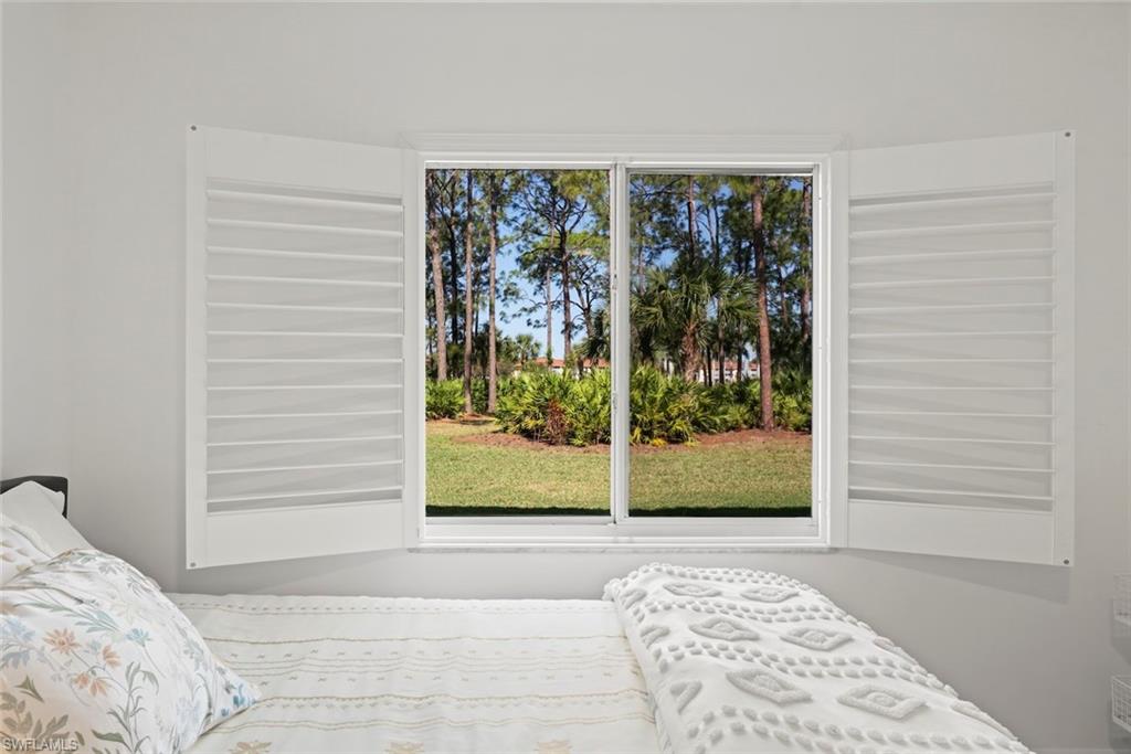 5965 Bloomfield Circle, Unit B104 Naples, FL 34112 - Photo 7 of 39 a view of a bedroom with a bed and glass window