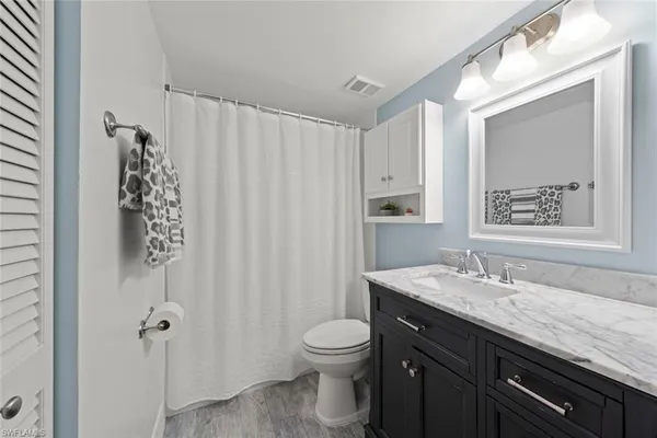a bathroom with a granite countertop sink toilet and shower