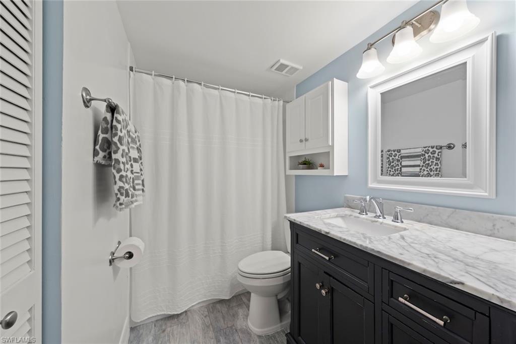 5965 Bloomfield Circle, Unit B104 Naples, FL 34112 - Photo 8 of 39 a bathroom with a granite countertop sink toilet and shower