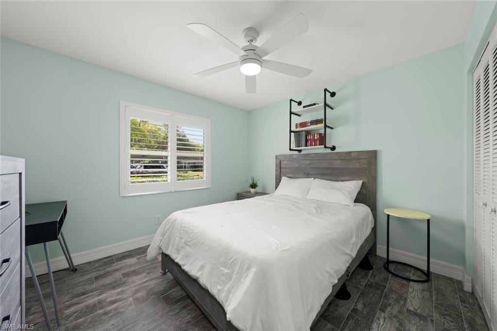 5965 Bloomfield Circle, Unit B104 Naples, FL 34112 - Photo 9 of 39 a bedroom with a bed and a chandelier