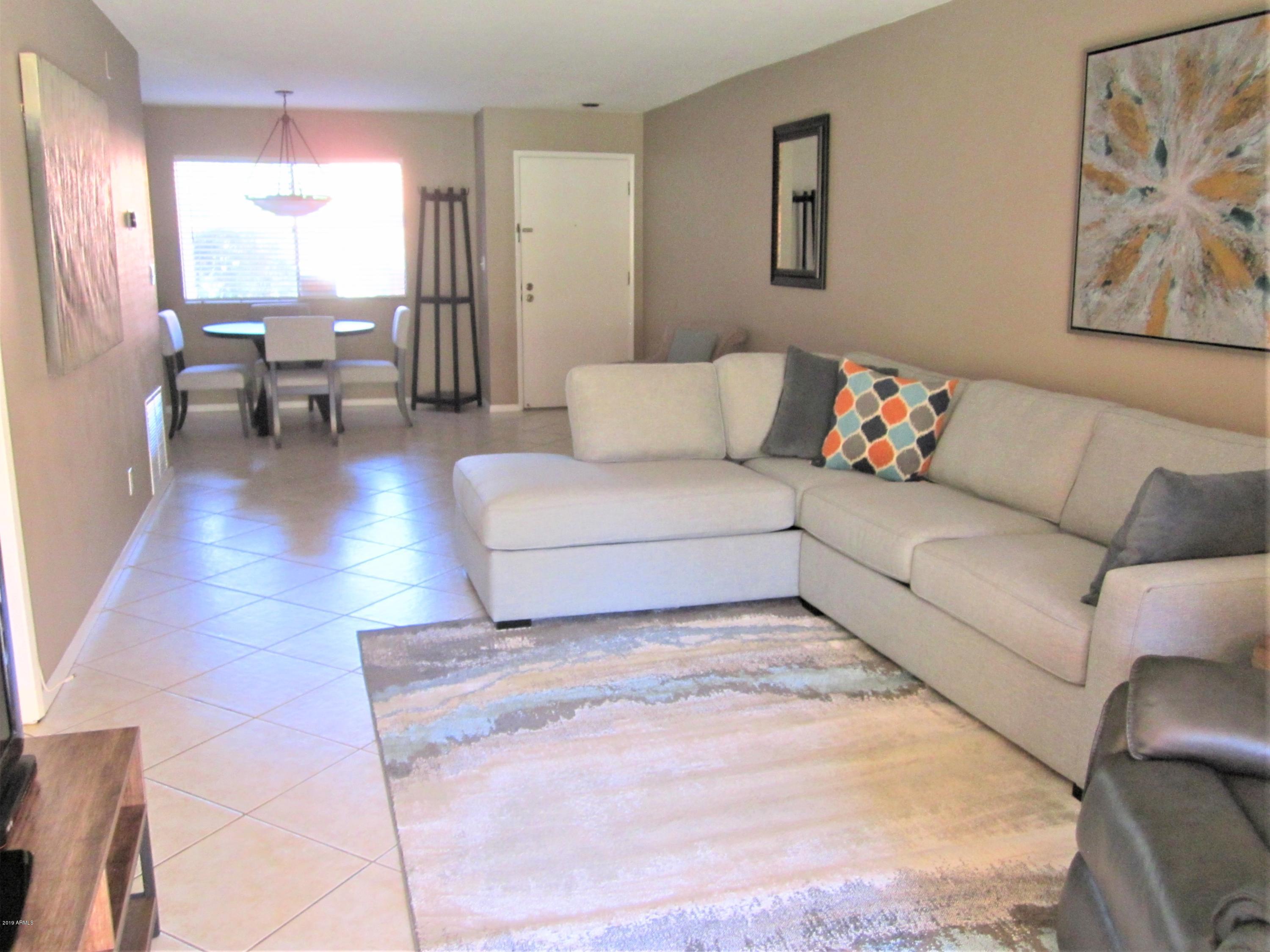 4303 East Cactus Road, Unit 116 Phoenix, AZ 85032 - Photo 3 of 35 a living room with furniture and a large window