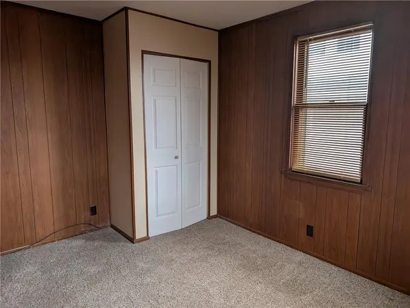 an empty room with windows and closet