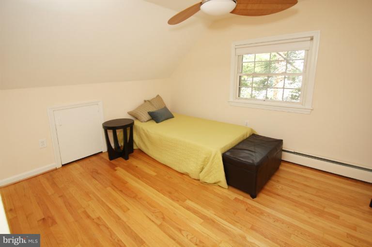 10209 Procter Street Silver Spring, MD 20901 - Photo 1 of 23 a bedroom with a bed and wooden floor