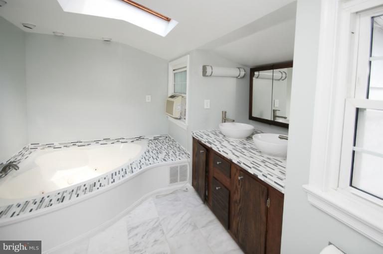 10209 Procter Street Silver Spring, MD 20901 - Photo 16 of 23 a bathroom with a granite countertop double vanity sink and a bathtub