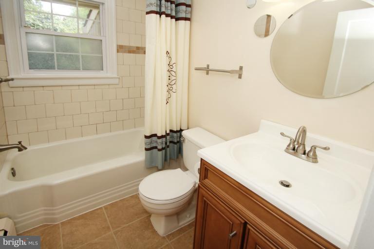 10209 Procter Street Silver Spring, MD 20901 - Photo 18 of 23 a bathroom with a sink a toilet and a mirror