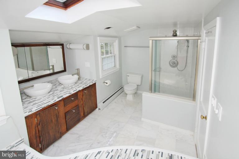 10209 Procter Street Silver Spring, MD 20901 - Photo 22 of 23 a bathroom with a granite countertop sink a toilet and shower