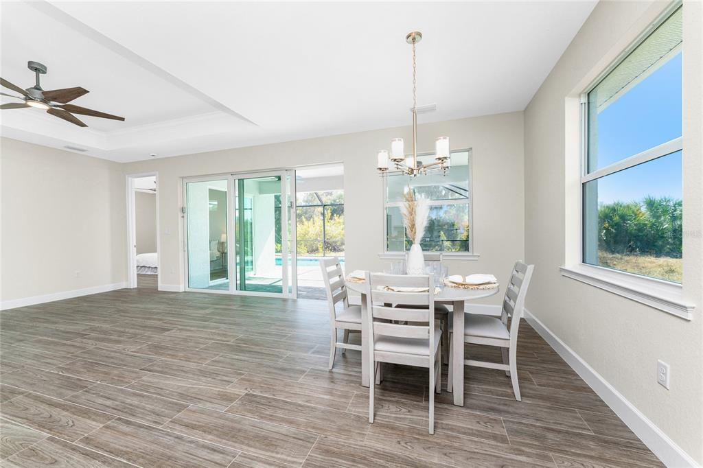 399 Sunset Road Rotonda West, FL 33947 - Photo 15 of 57 a view of a dining room with furniture window and wooden floor
