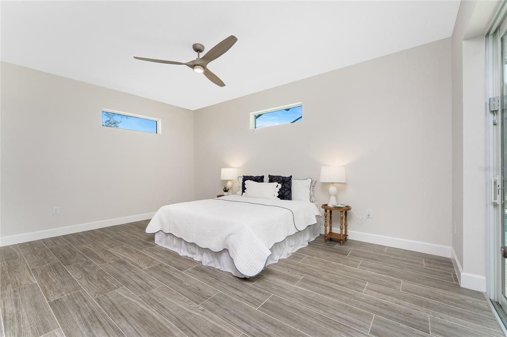 399 Sunset Road Rotonda West, FL 33947 - Photo 20 of 57 a bedroom with a bed and a ceiling fan