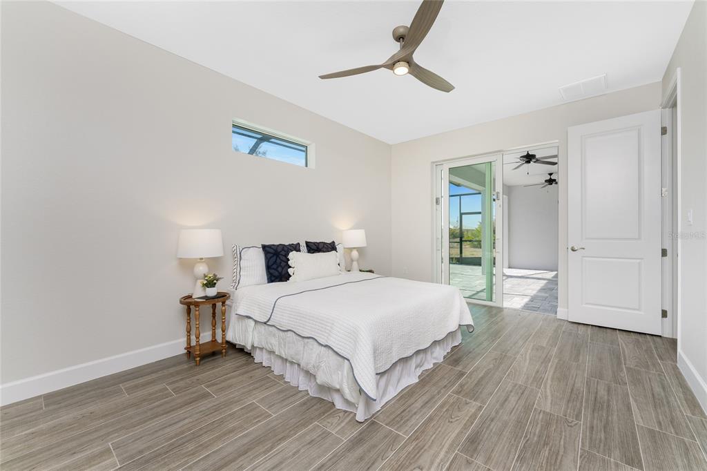 399 Sunset Road Rotonda West, FL 33947 - Photo 21 of 57 a bedroom with a bed and wooden floor