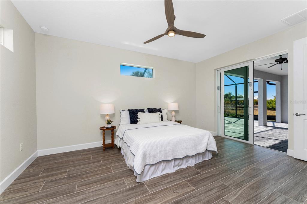 399 Sunset Road Rotonda West, FL 33947 - Photo 22 of 57 a bedroom with a bed and wooden floor