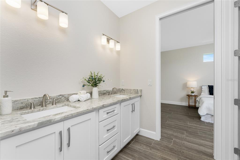 399 Sunset Road Rotonda West, FL 33947 - Photo 26 of 57 a spacious bathroom with a granite countertop sink and a mirror